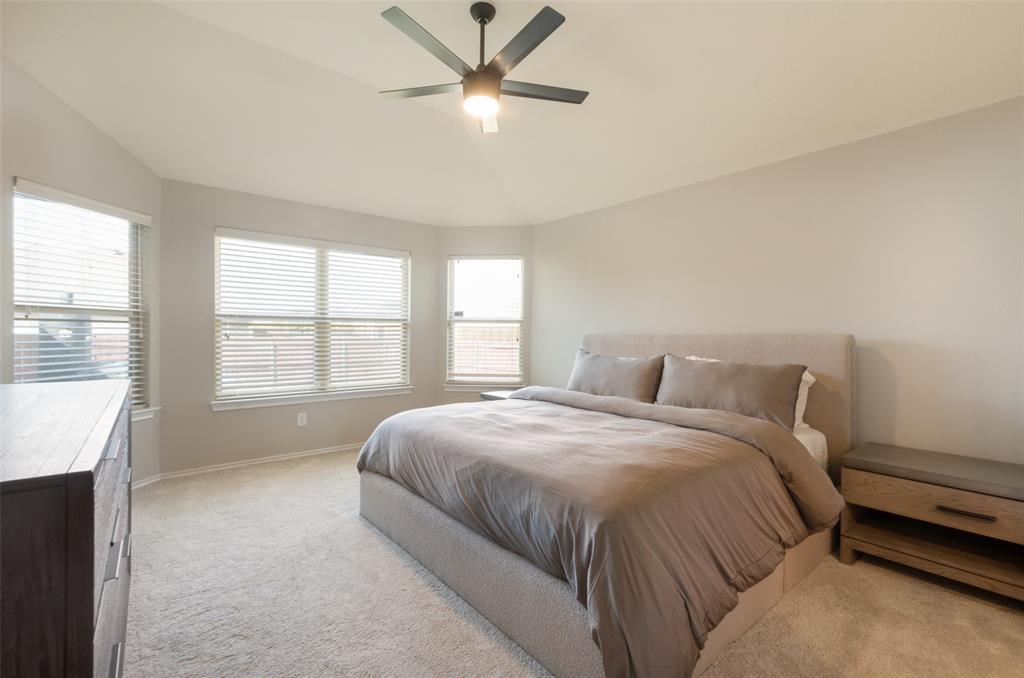Vaulted ceiling with a flush-mount ceiling fan, multiple windows with blinds, and neutral carpeting Vaulted ceiling with a flush-mount ceiling fan, multiple windows with blinds, and neutral carpeting