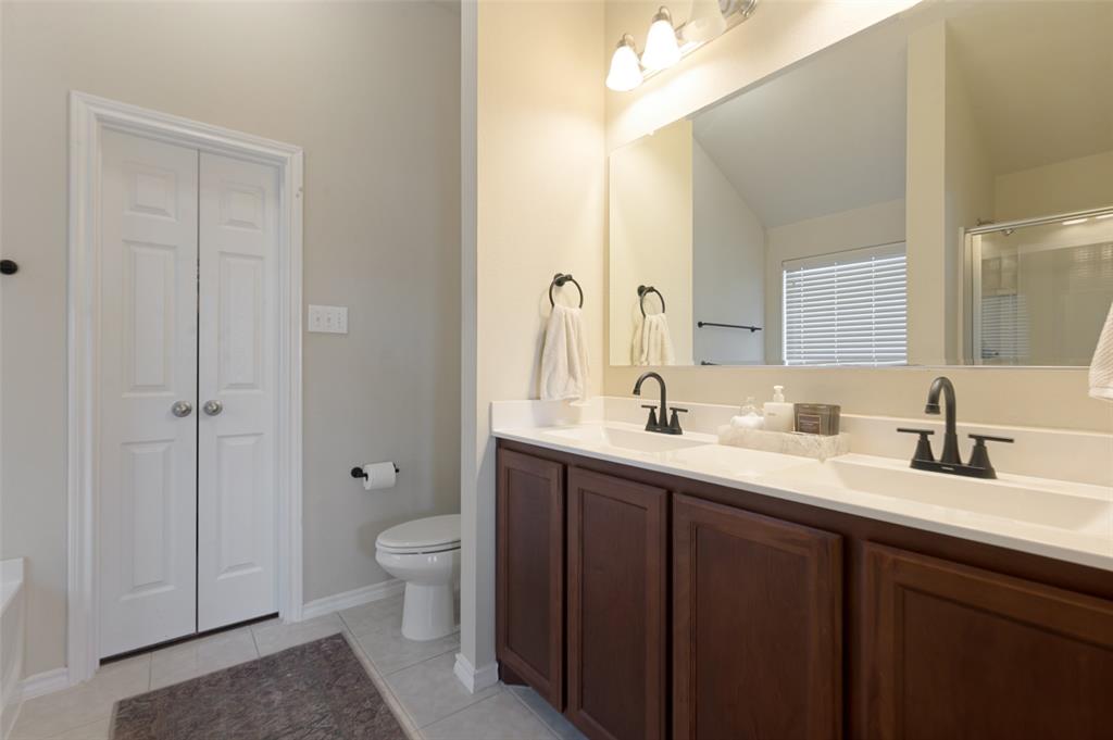 Double vanity with integrated sinks, dark wood-finish cabinetry, and matte black fixtures Double vanity with integrated sinks, dark wood-finish cabinetry, and matte black fixtures