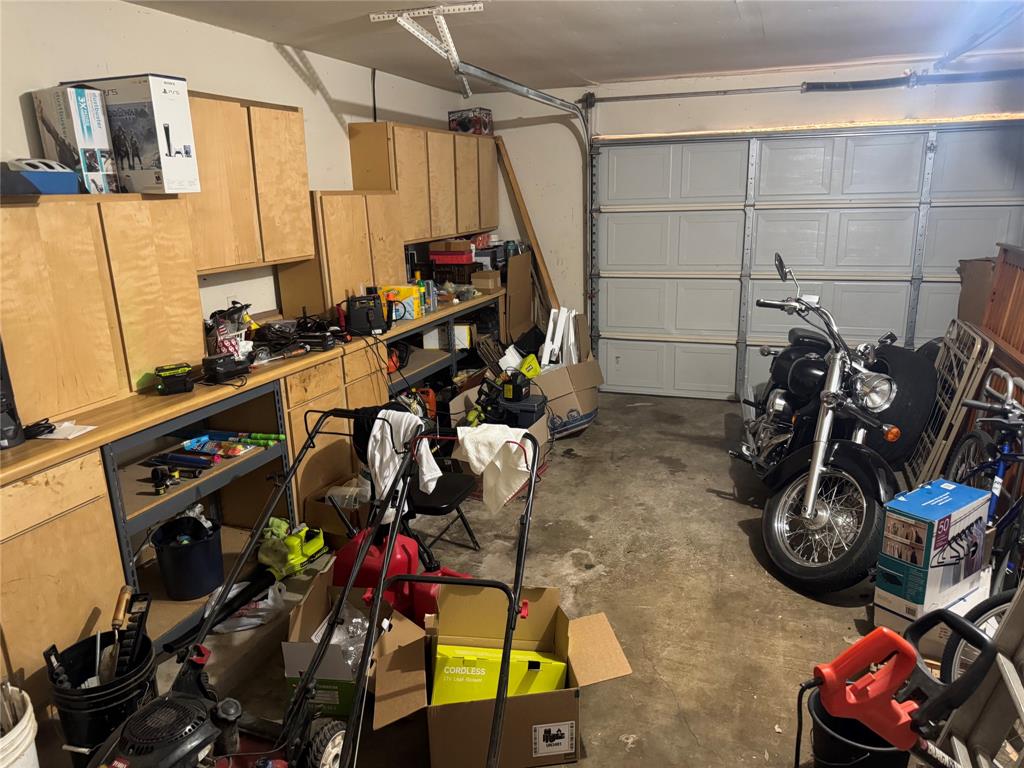 Garage with built-in cabinetry, workbench, and panel garage door