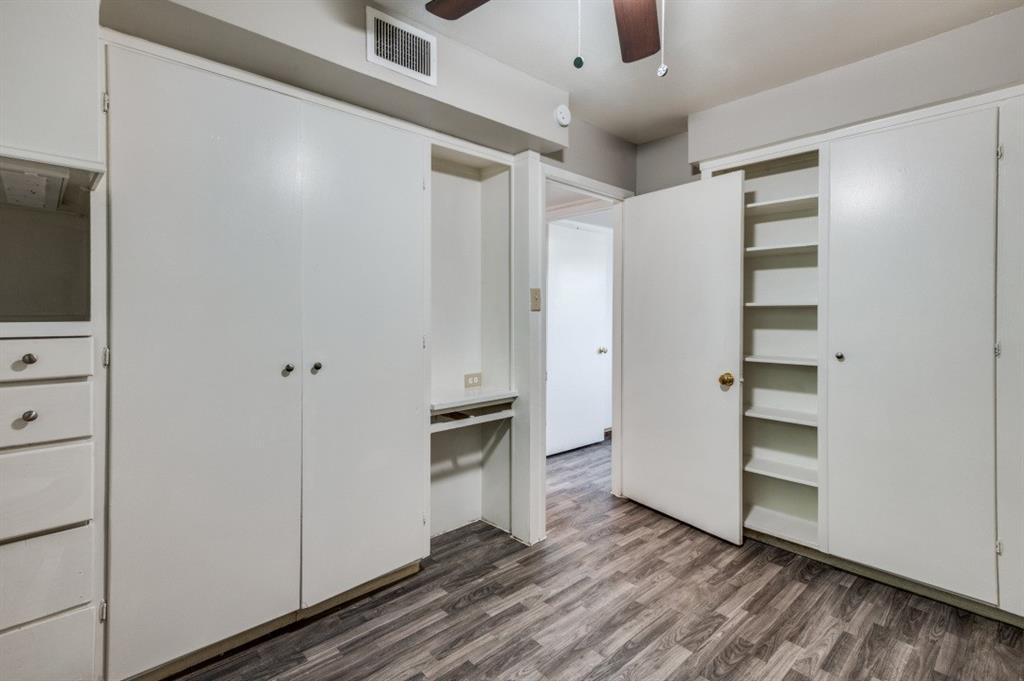 Wood-finish flooring throughout, integrated cabinetry, built-in shelving, and a ceiling fan