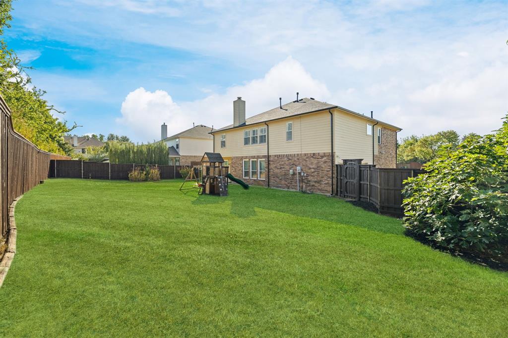 Expansive green lawn with a wooden fence boundary