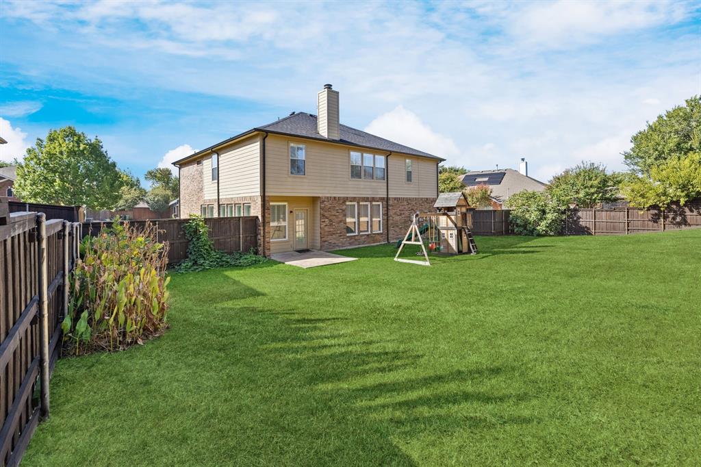 Expansive green lawn with a privacy fence