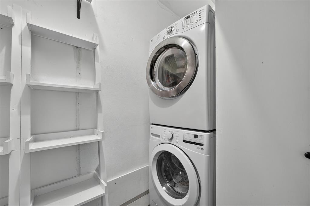 White stacked laundry appliances and white built-in shelving
