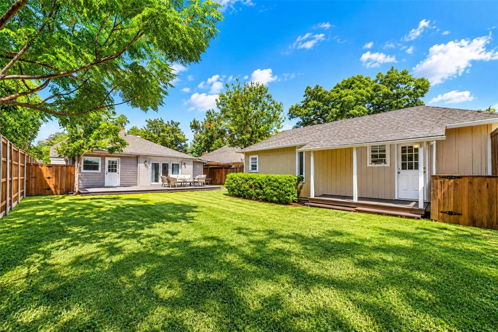 Expansive grassy lawn with a wood fence perimeter