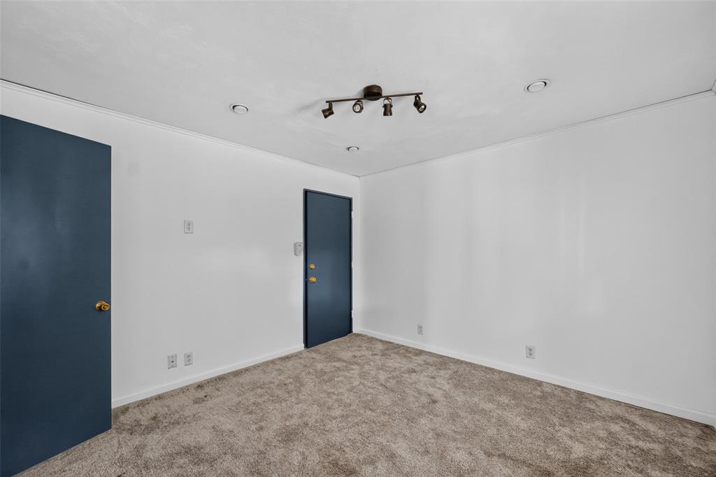 White walls with crown molding, track lighting, two recessed ceiling lights, and two doors