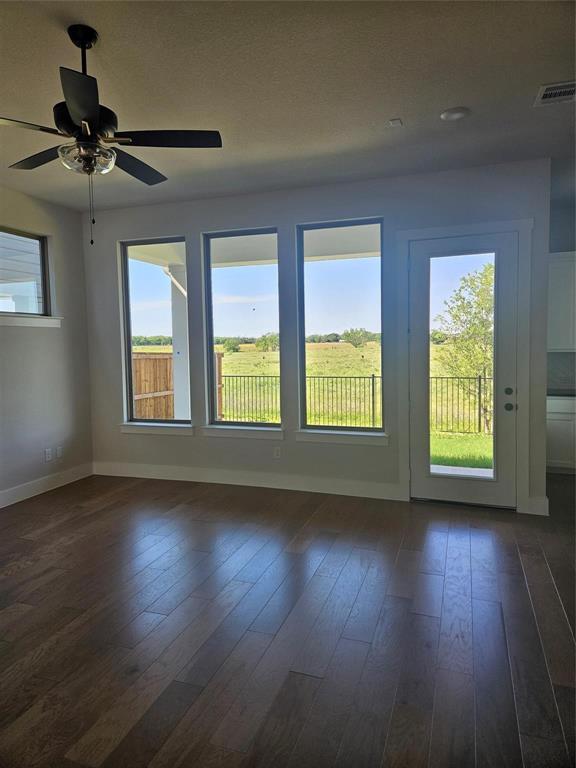 Wood-finish flooring, multiple windows, ceiling fan, glass-panel door, and recessed lighting