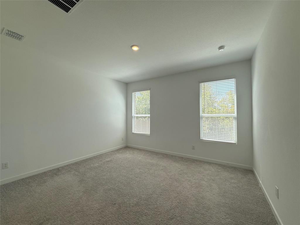 Light-toned wall-to-wall carpeting, two windows with blinds, recessed ceiling lighting, and crisp white walls