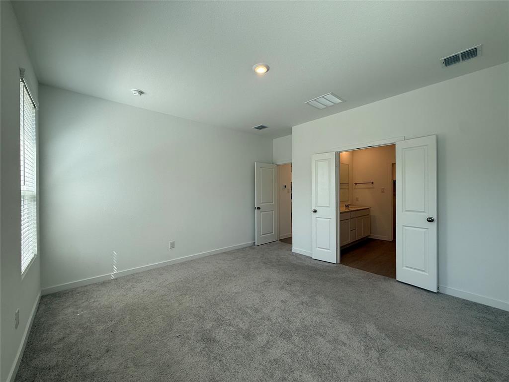 Plush gray carpeting, white walls, and a window with horizontal blinds