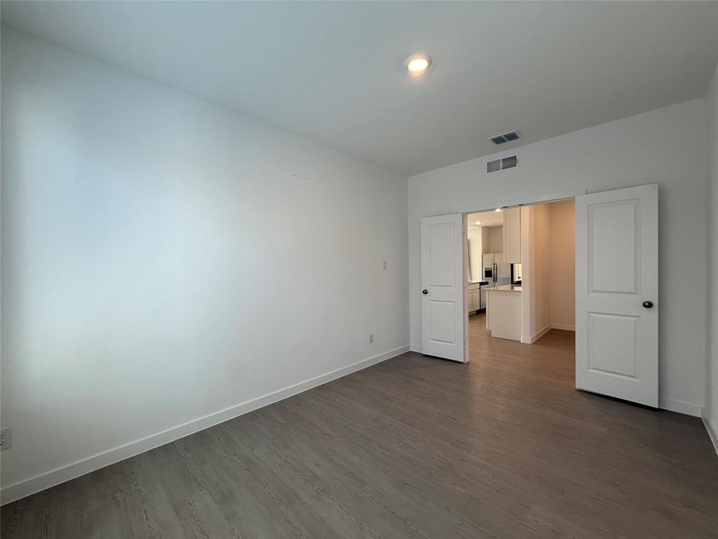 Neutral wall finishes, wood-finish flooring, recessed ceiling lighting, and double panel doors