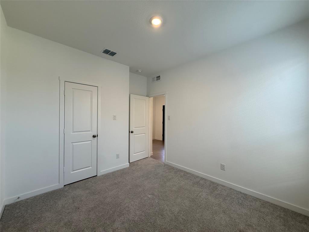 Plush grey carpeting, white interior doors, and a recessed ceiling light