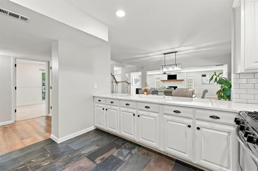 Fresh white cabinetry and backsplash set off the kitchen hardware.