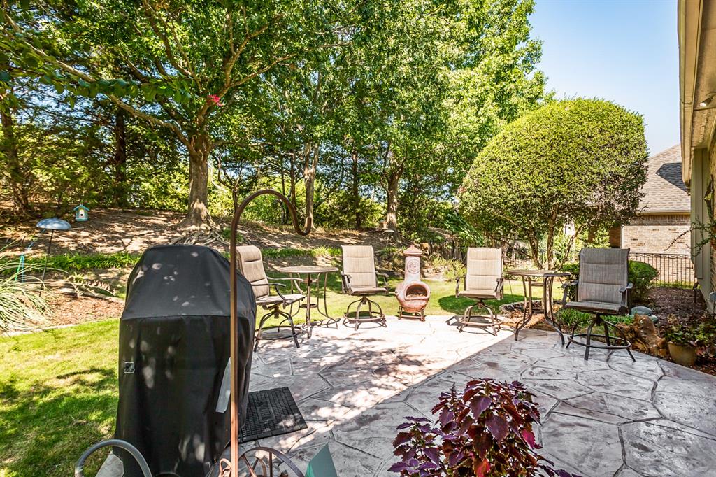 Stamped concrete patio with a landscaped perimeter and mature trees