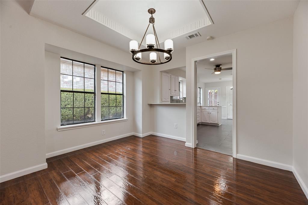 Hardwood flooring, recessed ceiling with crown molding, chandelier, and a breakfast bar Hardwood flooring, recessed ceiling with crown molding, chandelier, and a breakfast bar