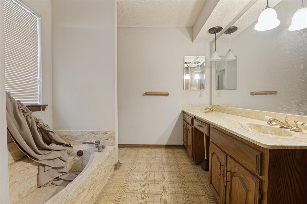 Dual vanity with integrated sinks, stone-look countertop, and wood cabinetry