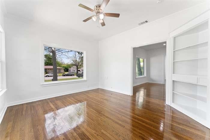 Hardwood flooring, recessed doorway, ceiling fan, white built-in shelving, white trim