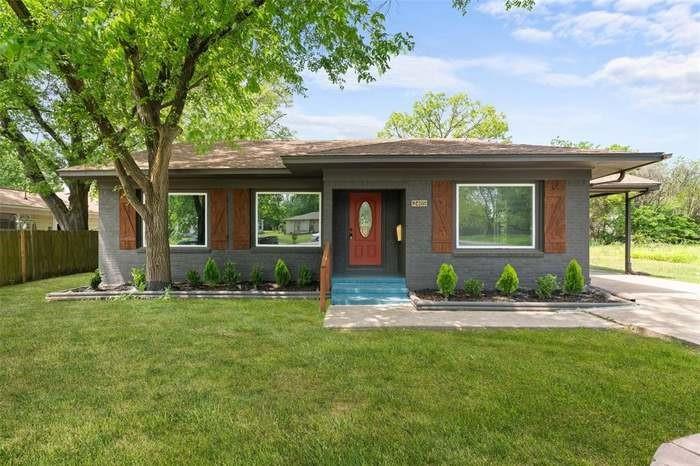 Gray exterior with wood shutters, red entry door, and a covered carport Gray exterior with wood shutters, red entry door, and a covered carport