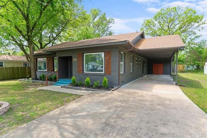 Brick-clad exterior with wood shutters, covered carport, and paved driveway Brick-clad exterior with wood shutters, covered carport, and paved driveway