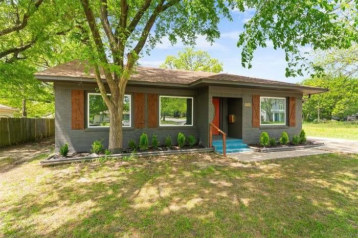 Charcoal brick exterior with wood-finish shutters, a covered entry, and a contrasting bright blue front step Charcoal brick exterior with wood-finish shutters, a covered entry, and a contrasting bright blue front step