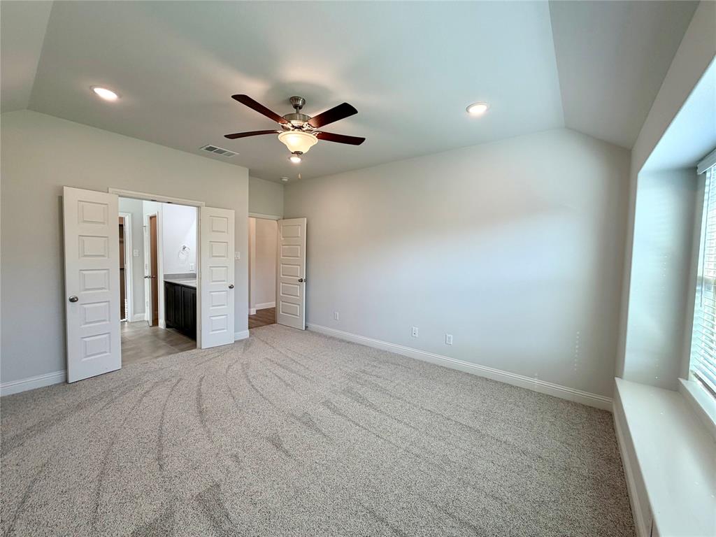 Another view of the the spacious and well-appointed primary bedroom suite, highlighting the elegant design, natural lighting, and overall comfortable layout of the room.