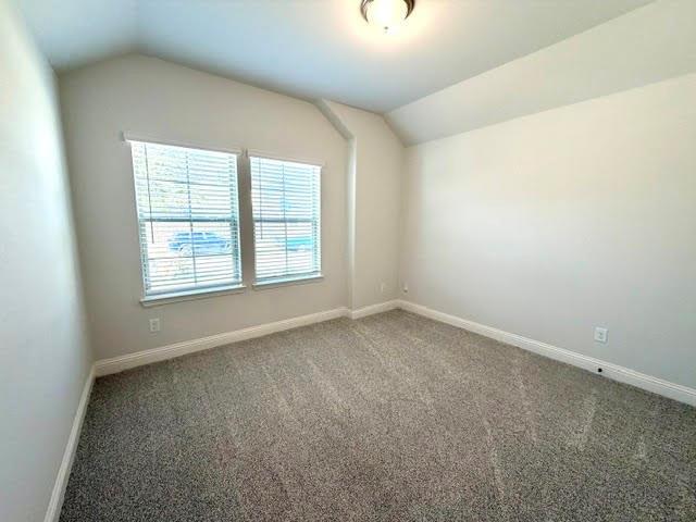 This spacious front secondary bedroom is bathed in natural light, featuring high, airy ceilings and dual windows adorned with sleek blinds. The room is finished with a calming, neutral paint palette and plush wall-to-wall carpet flooring, creating a comfortable and inviting atmosphere perfect for guests or family members.