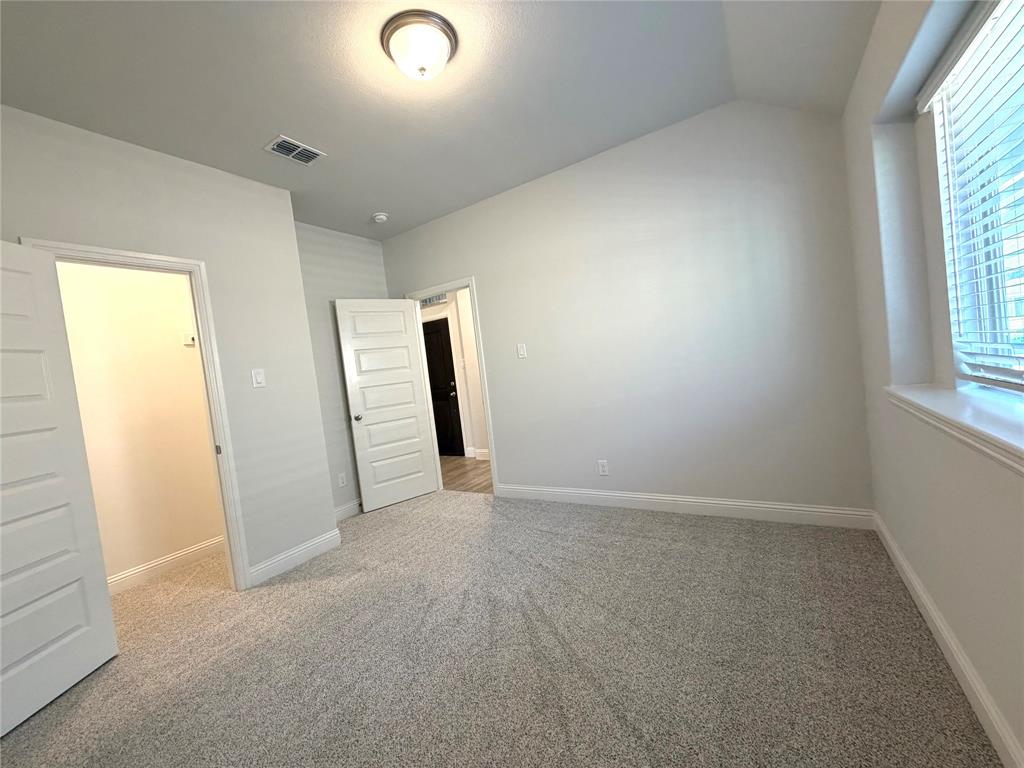 Another view of secondary bedroom 2 with a walk-in closet & a deep window ledge.