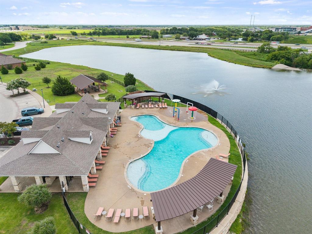 Community pool with integrated water features, adjacent to a large body of water