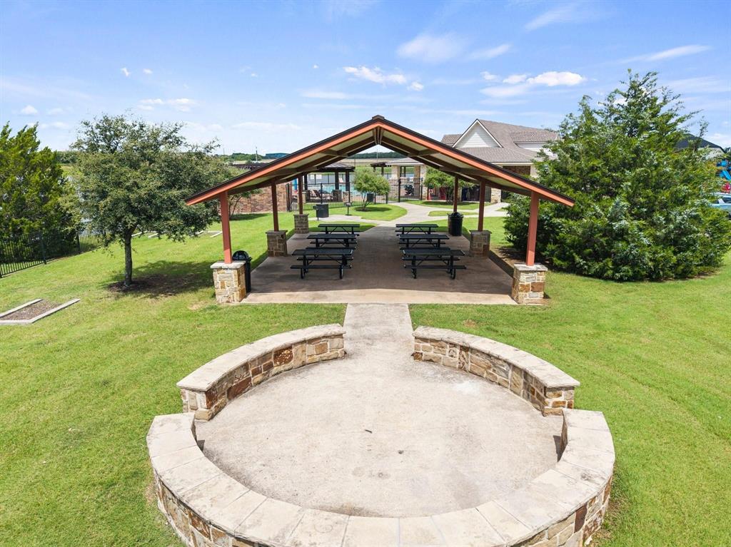 Covered outdoor pavilion with stone-clad columns, a concrete floor, and an open gable roof