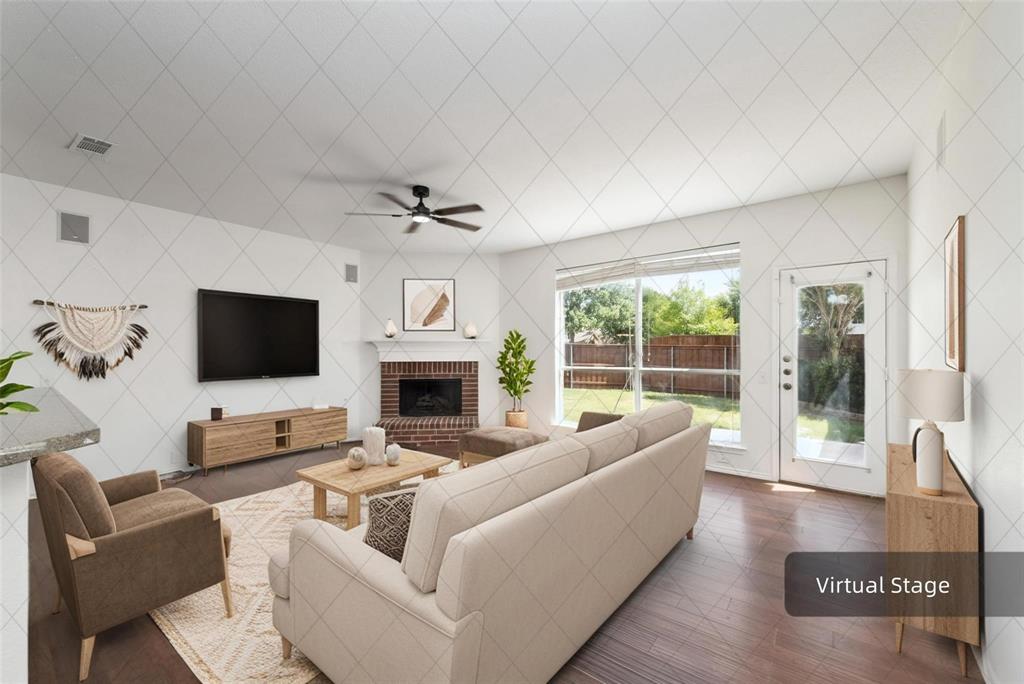 Vaulted ceiling with a ceiling fan, brick fireplace with a mantel, wood-finish flooring, large window, and a glass-paned door