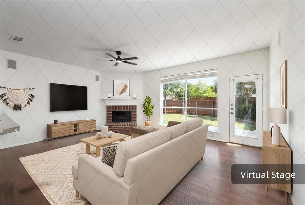 Hardwood-finish flooring, brick fireplace with mantel, ceiling fan with integrated lighting, glass-paneled exterior door, and large window