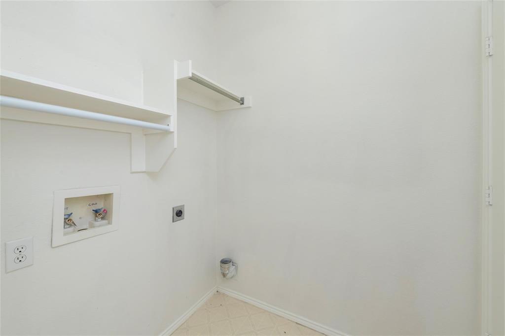 Laundry area featuring a utility sink connection, built-in shelving, and a hanging rod
