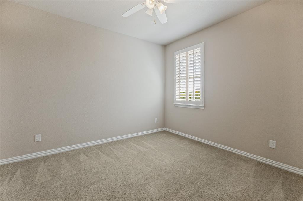 Second upstairs bedroom with ceiling fan and plantation shutters