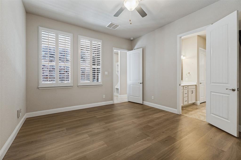 Wood flooring, plantation shutters, ceiling fan, and 8 ft paneled doors