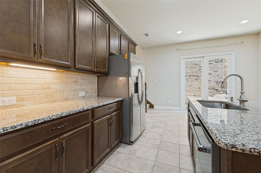 Rich wood-finish cabinetry, granite countertops, subway tiled backsplash