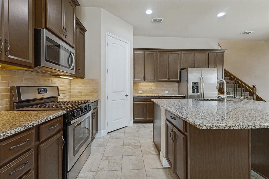 Kitchen featuring gas cooktop range, built-in microwave, extensive cabinetry and tile flooring
