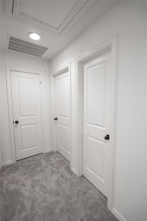 White interior doors with black hardware, plush gray carpet flooring, recessed ceiling lighting, and a framed attic access panel