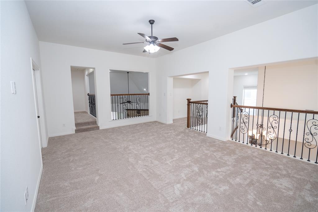 Carpeted open-concept bonus room with a ceiling fan