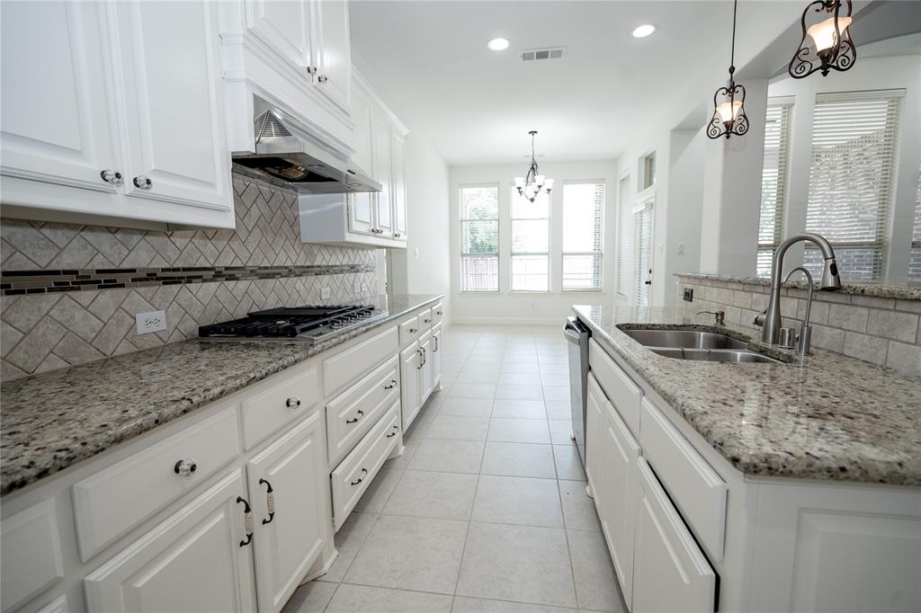 White cabinetry paired with granite countertops, a tiled backsplash, a stainless steel gas range with a coordinating hood, and a dual basin sink with a pull-down faucet