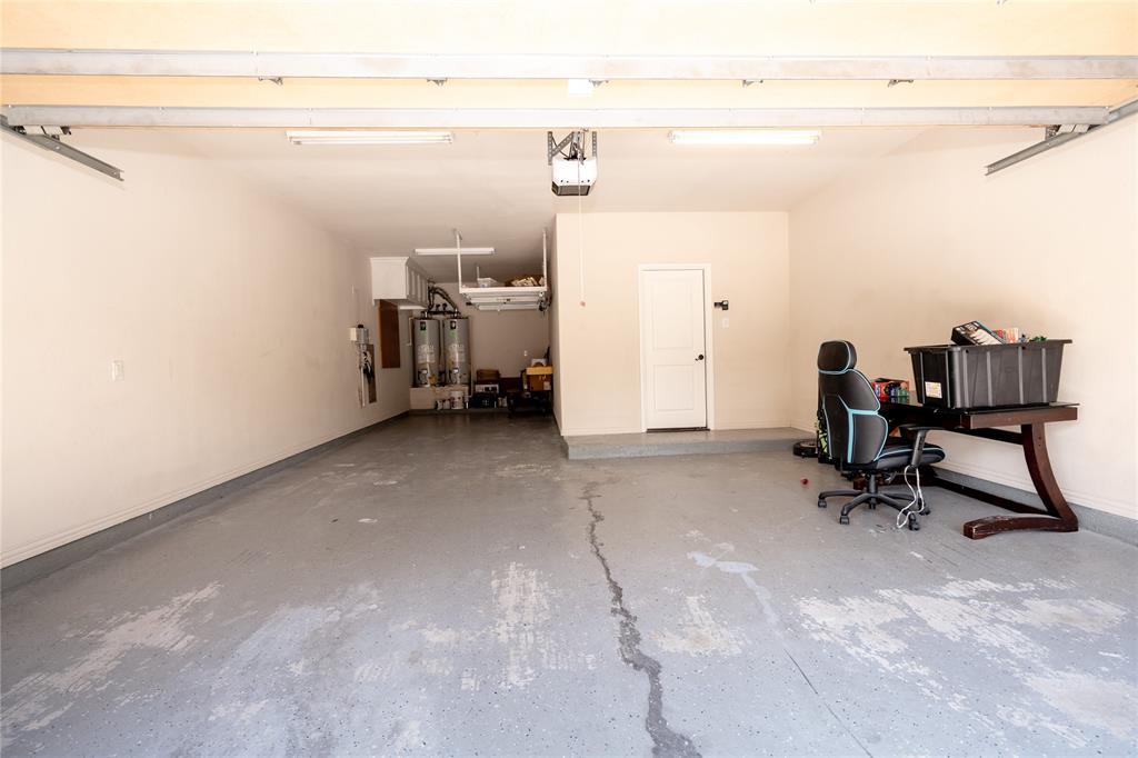 Expansive garage space featuring a light gray epoxy floor and overhead fluorescent lighting