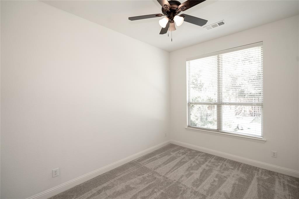 Window with blinds, ceiling fan with integrated lighting, and neutral carpeting