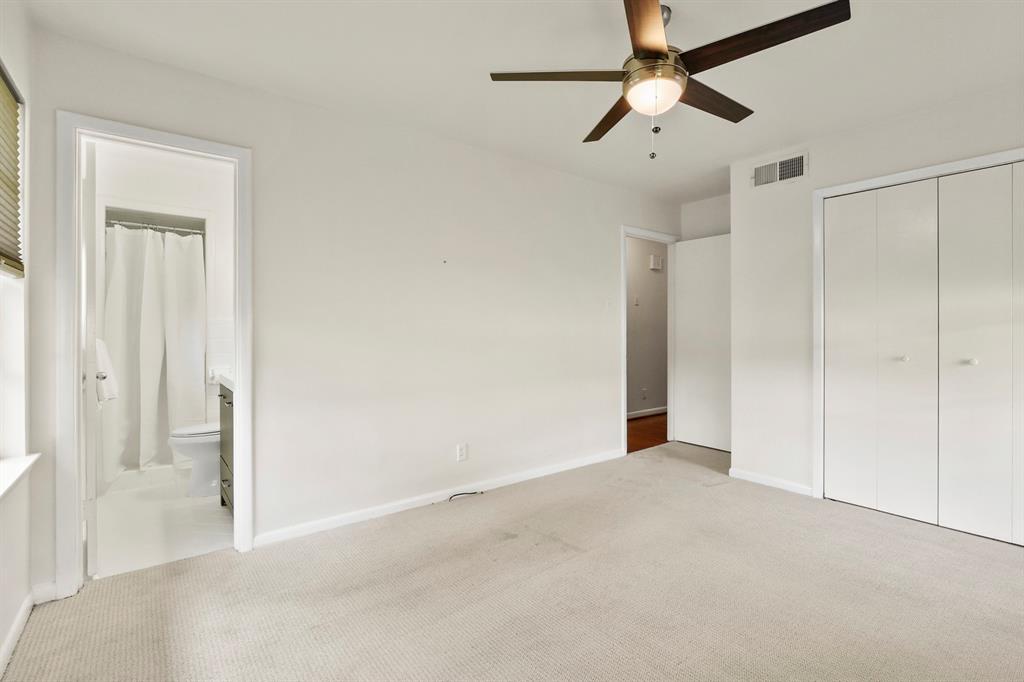 Carpeted room with a ceiling fan, window with blinds, and built-in closet with bi-fold doors