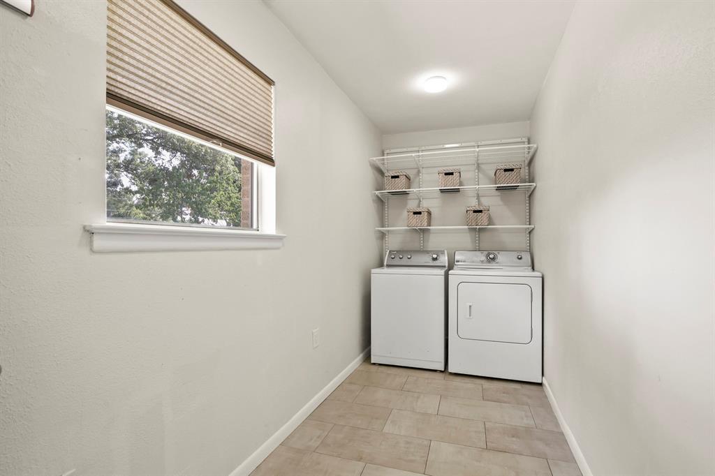 Recessed lighting, tile flooring, window with pleated shade, and built-in shelving system