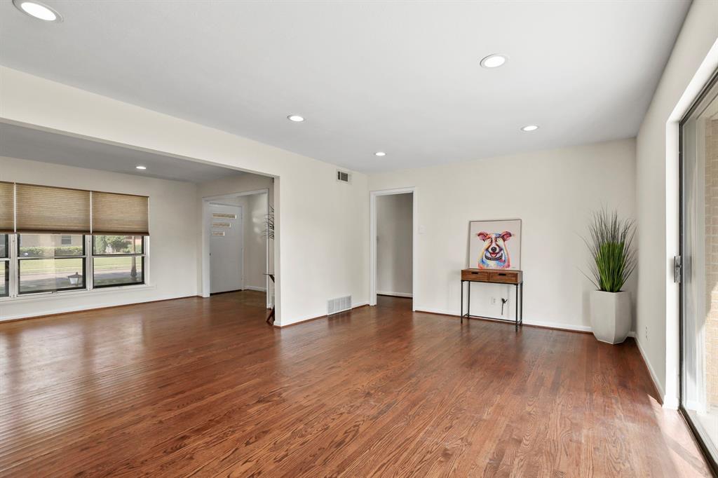 Hardwood flooring throughout, recessed lighting, and multiple windows with blinds
