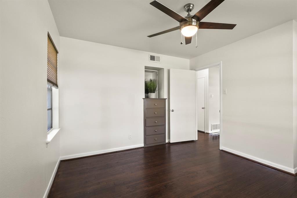 Wood-finish flooring, ceiling fan with integrated lighting, white walls, and white trim