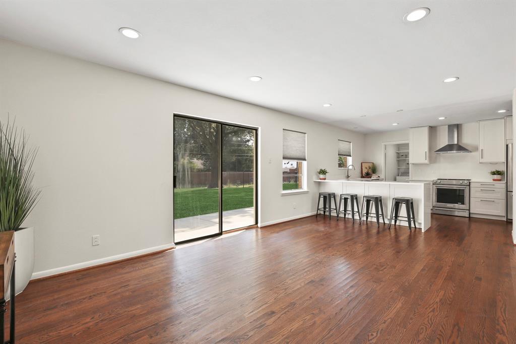 Open-concept living space with dark wood-finish flooring, recessed lighting, and sliding glass doors leading to a private outdoor area