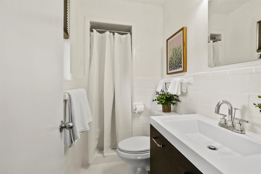 Integrated vanity with a single basin, chrome faucet, and dark wood-finish cabinetry
