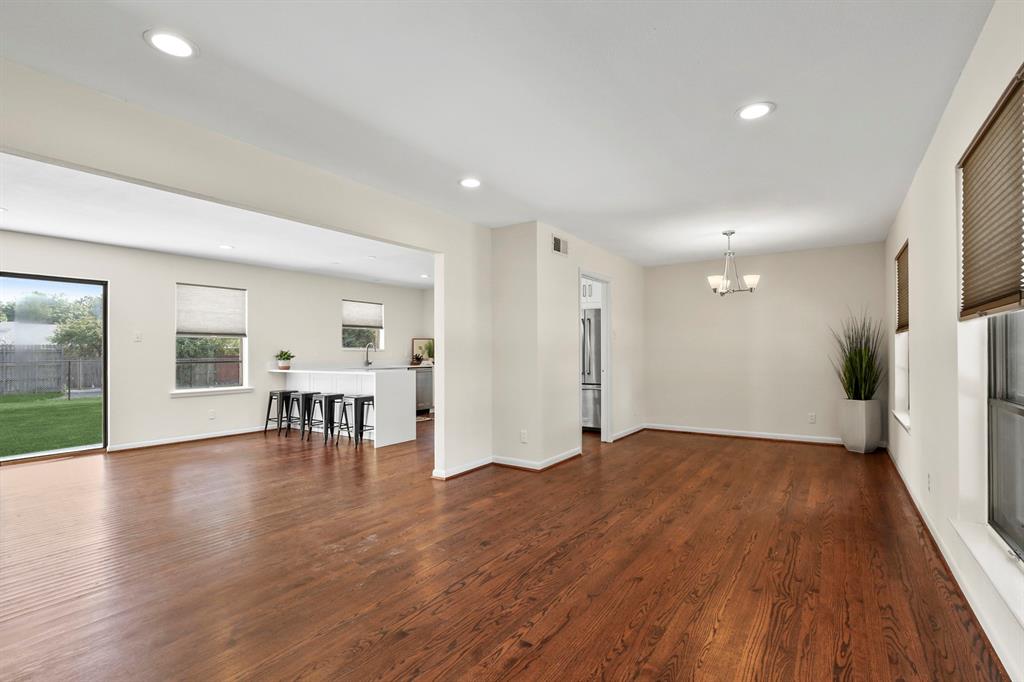 Wood-finish flooring throughout, recessed lighting, and a modern kitchen island with seating