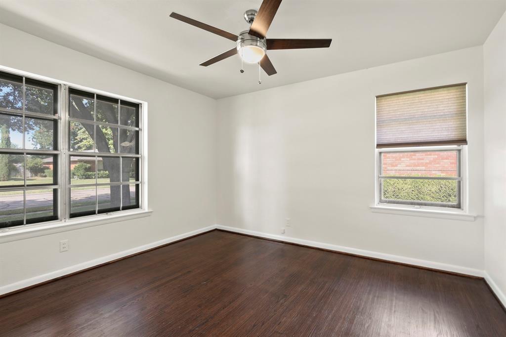 Dark wood-finish flooring, white walls, and a ceiling fan with light fixture
