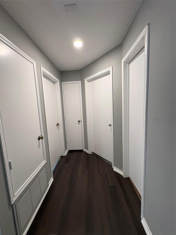 Wood-finish flooring with crisp white trim, recessed lighting, and bright white doors