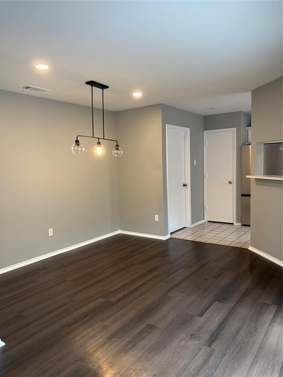 Recessed ceiling lighting, wood-finish flooring, modern linear chandelier, neutral wall tones, and white interior doors Recessed ceiling lighting, wood-finish flooring, modern linear chandelier, neutral wall tones, and white interior doors