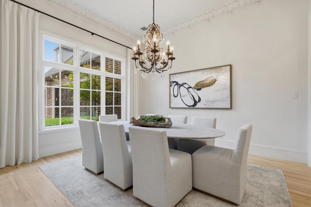 The formal dining room is filled with natural light and detailed with elegant millwork and a statement chandelier. The formal dining room is filled with natural light and detailed with elegant millwork and a statement chandelier.